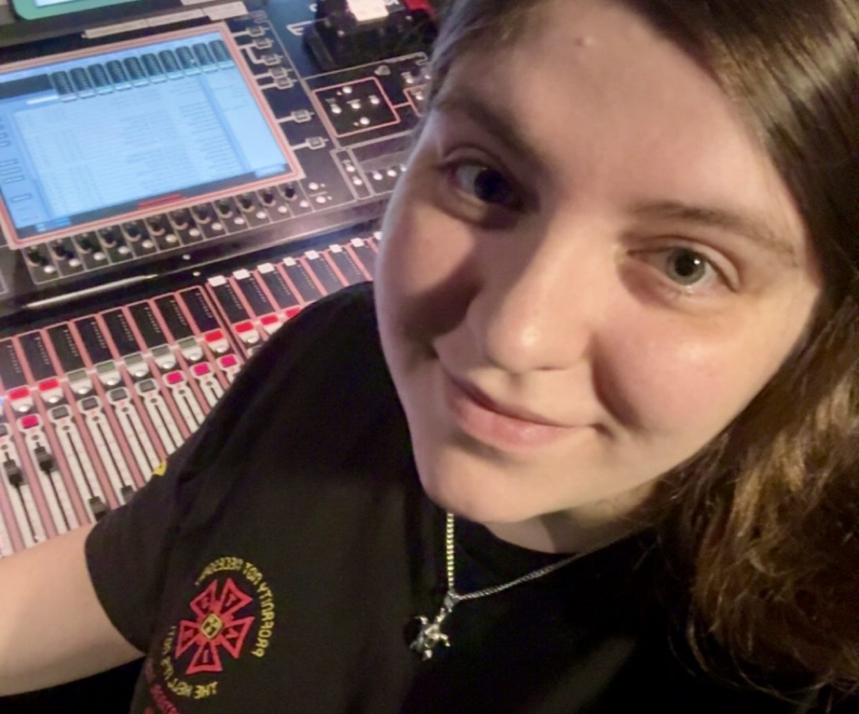 Picture of Fia Goudes, white with brown hair, behind a DiGiCo SD9 sound console.